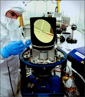 Engineer (in a "bunny suit") working on the Scene Select Mechanism of the Thermal Infrared Sensor (TIRS) that will fly on LDCM.