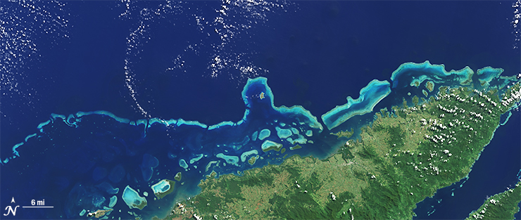 The sensors aboard Landsat 8 were designed to have higher sensitivity to brightness and color; they use 4,096 values to digitize their signals (12-bit data) whereas the last-generation sensor on Landsat 7 was slightly less sensitive and used only 256 data values (8-bits) to describe the range of brightness it recorded. Visually, this translates into a smoother, less noisy looking images as can been seen here when comparing these natural color Landsat 7 [left] and Landsat 8 [right] images of the extensive coral reefs on the northern shore of Vanua Levu, Fiji’s second largest island, acquired on September 19, 2002 and May 10, 2015, respectively.