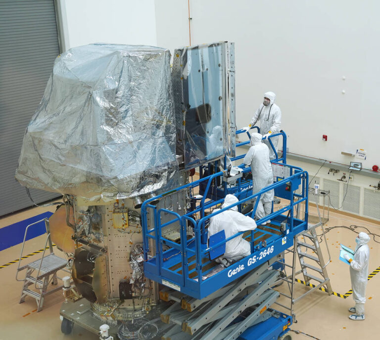 Engineers work on the newly integrated Landsat 9 satellite in a cleanroom