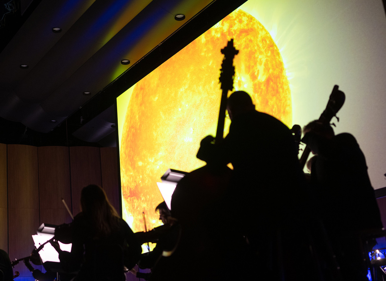National Philharmonic playing with NASA imagery of the Sun in the background.