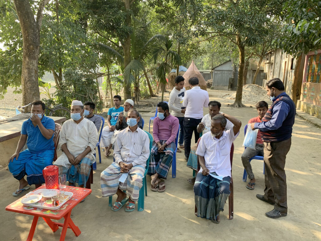 A group of Bangladeshi farmers seated in chairs gather outside to be part of an IRAS focus group in 2021. 