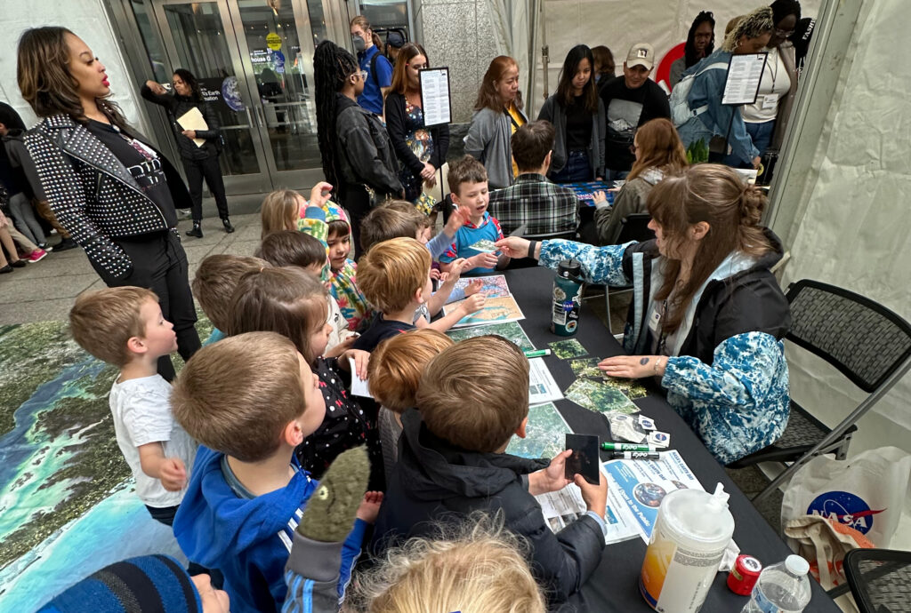 Allison Nussbaum hands out matching cards for the Chesapeake Bay mat to a group of elementary schoolers.