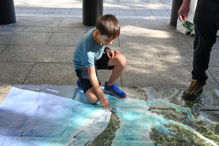 A student visitor matches a card to the correct location on the Chesapeake Bay mat.