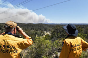 Members of Australia’s New South Wales Rural Fire Service monitor a fire in a remote region of the state that is also home to utility company transition lines. Credit: Indji Systems.