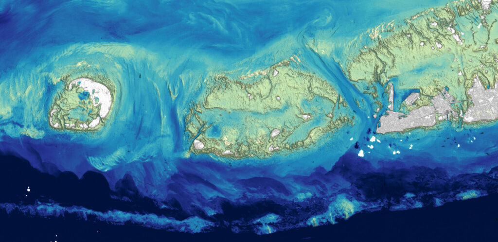 A Landsat-derived depth map that shows shallow channels cutting between low-lying islands, also called cays or keys. The shallow linear feature running across the bottom of the image is part of Florida’s stretch of coral reefs, which spans 350 miles (560 kilometers) from end to end.