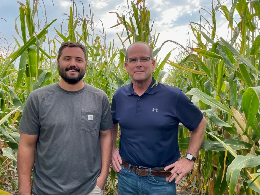 Dwane Roth (right), a fourth generation grain farmer in Finney County, Kansas, stands with nephew Zion (left) in one of their corn fields. Roth’s farm became one of the first Water Technology Farms in Kansas around 2016, and he has been using OpenET data for the past few years to track evapotranspiration rates and conserve water. Photo courtesy of Dwane Roth